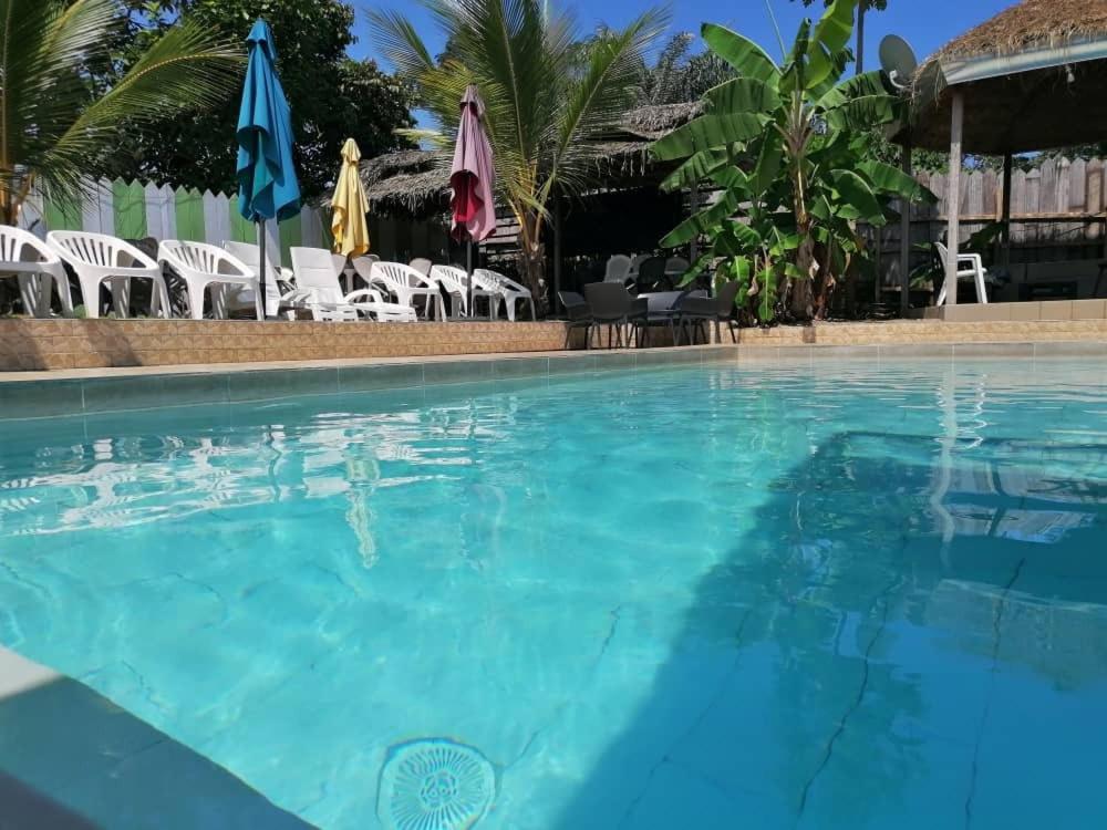 uma grande piscina com cadeiras e guarda-sóis em Résidence Hôtelière l'Océane em Kribi