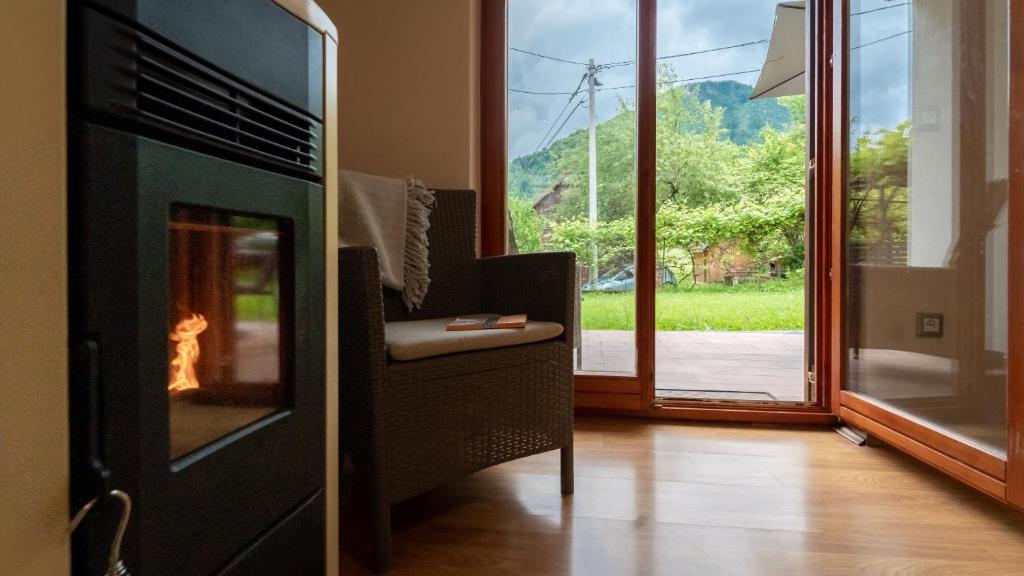 a living room with a fireplace with a view at Holiday house Kajfes in Brod na Kupi