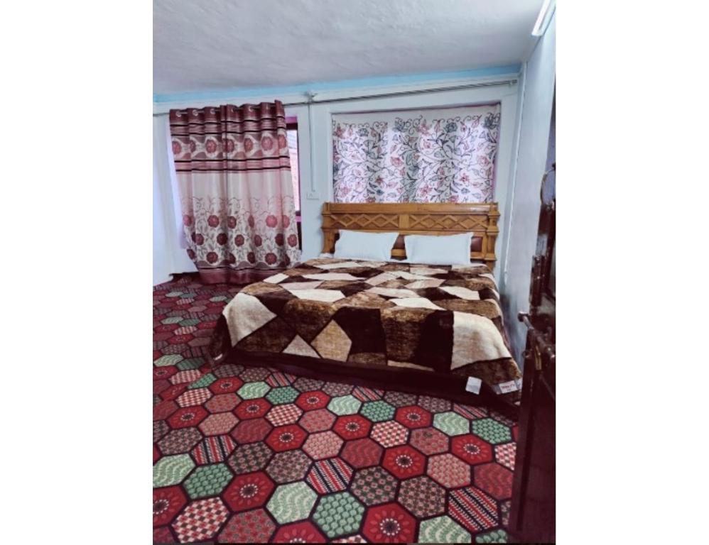 1 dormitorio con 1 cama con alfombra colorida en Hotel Prem Rose, Pahalgam, en Pahalgām