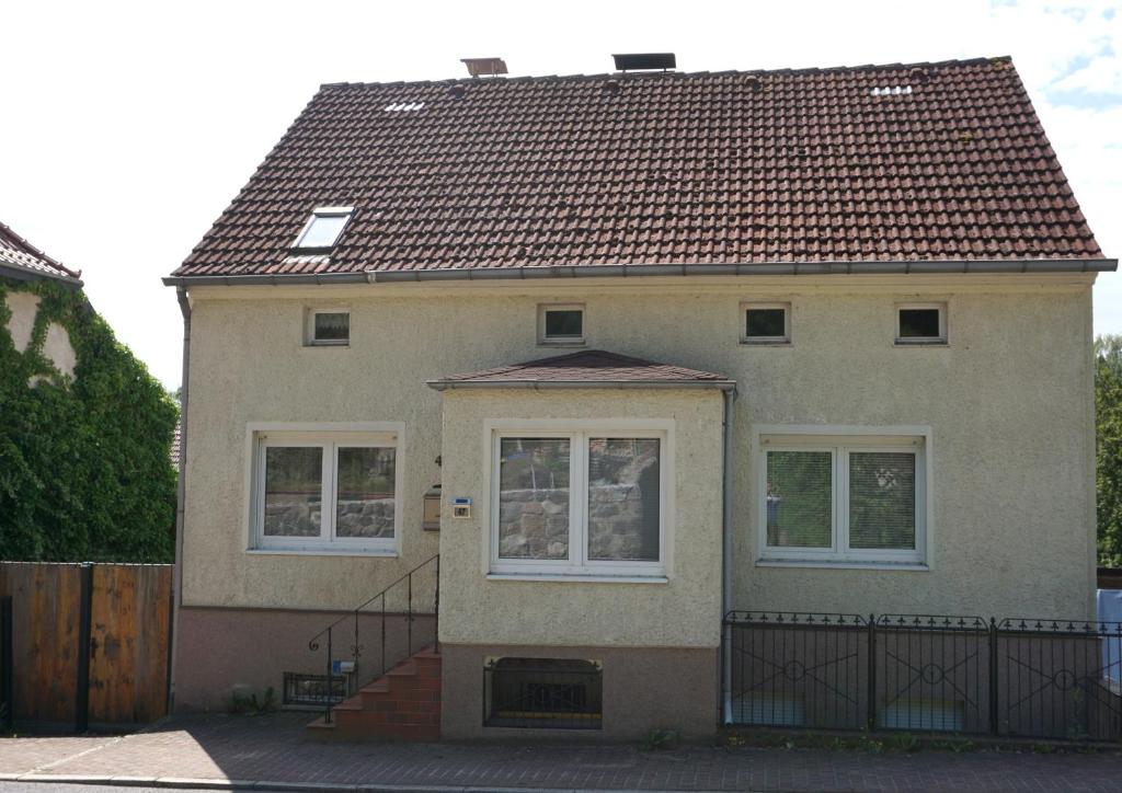 a house with a tiled roof on a street at Ferienwohnung Oderwind in Oderberg