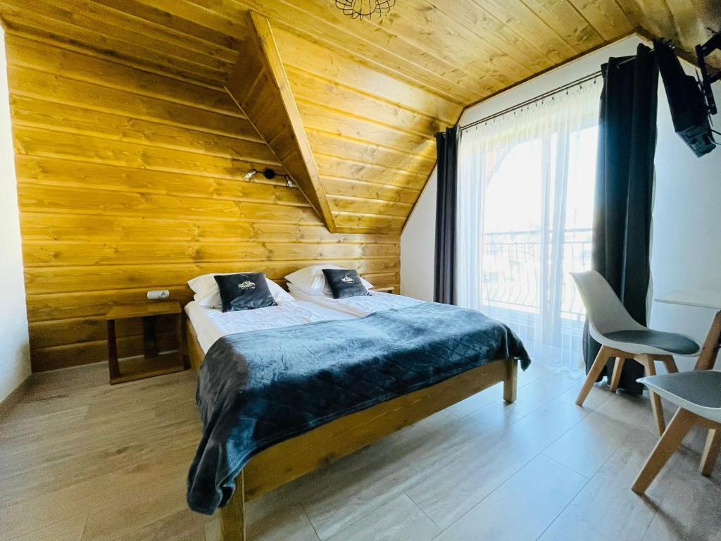 a bedroom with a bed with a wooden ceiling at Gąsienicowy Widok in Poronin