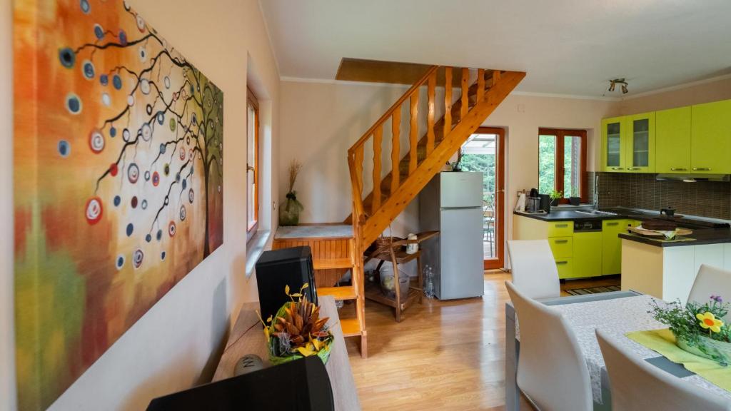 a kitchen and living room with a staircase and yellow cabinets at Holiday house Kajfes in Brod na Kupi