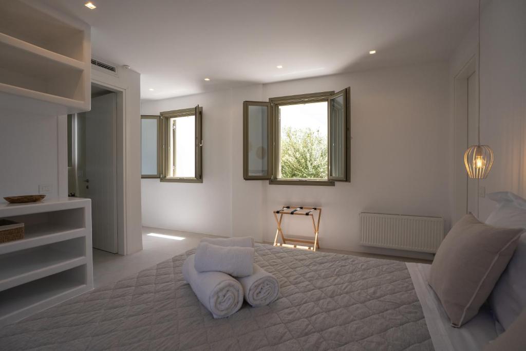 a white room with a bed and a window at Paros Breeze Luxury Villa in Drios
