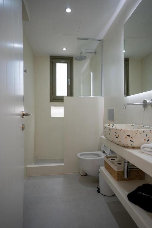 a white bathroom with a toilet and a sink at Paros Breeze Luxury Villa in Drios