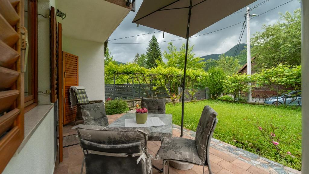 a patio with a table and chairs and an umbrella at Holiday house Kajfes in Brod na Kupi