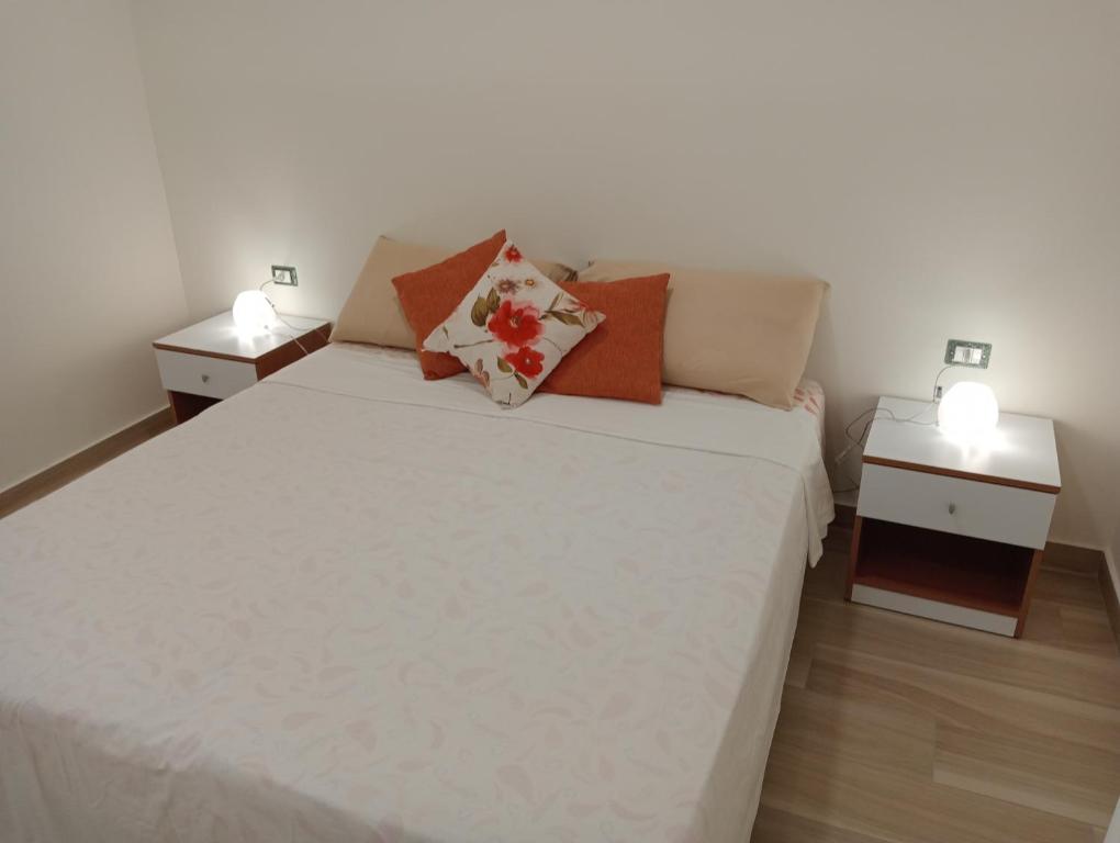 a bedroom with a large white bed with two night stands at Butterfly Apartments in Palermo