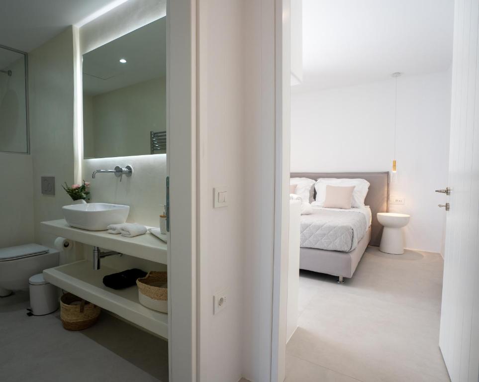a white bathroom with a bed and a sink at Paros Breeze Luxury Villa in Drios