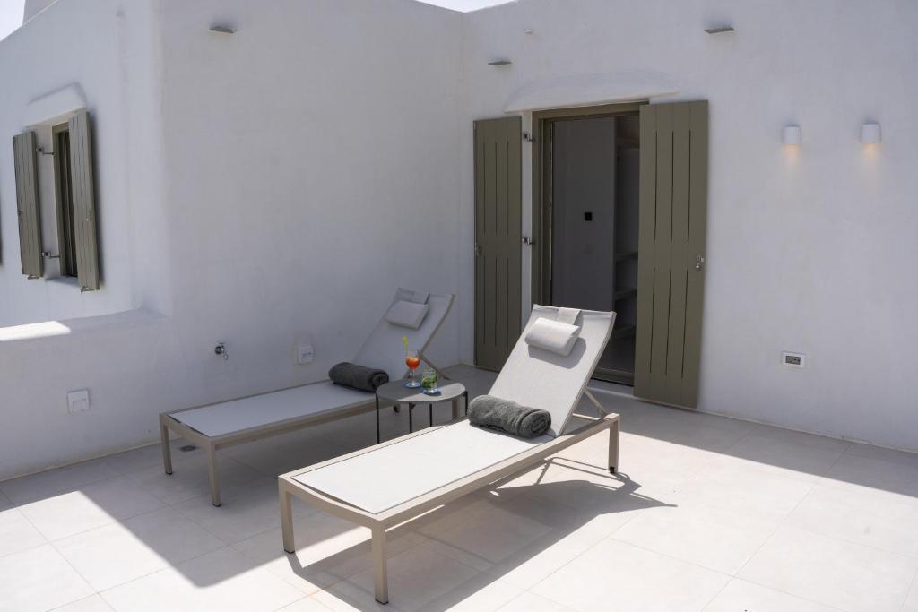 a white room with a bench and a chair at Paros Breeze Luxury Villa in Drios
