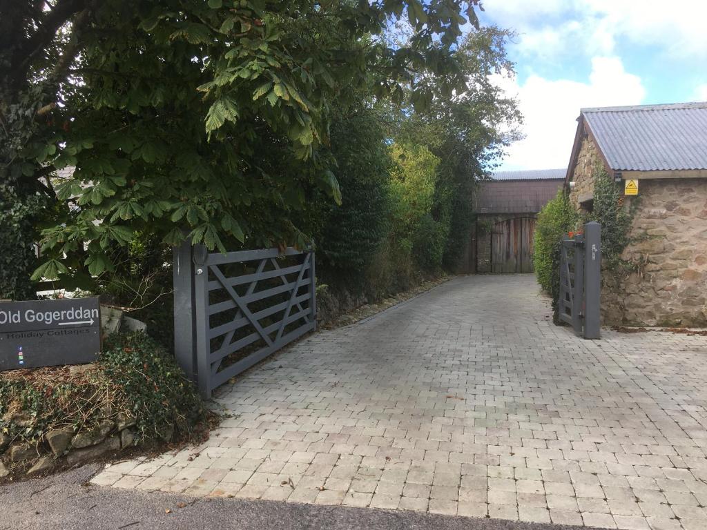 a driveway with a gate in front of a house at Chestnut,1 bedroom loft apartment with wood burner in Cardigan