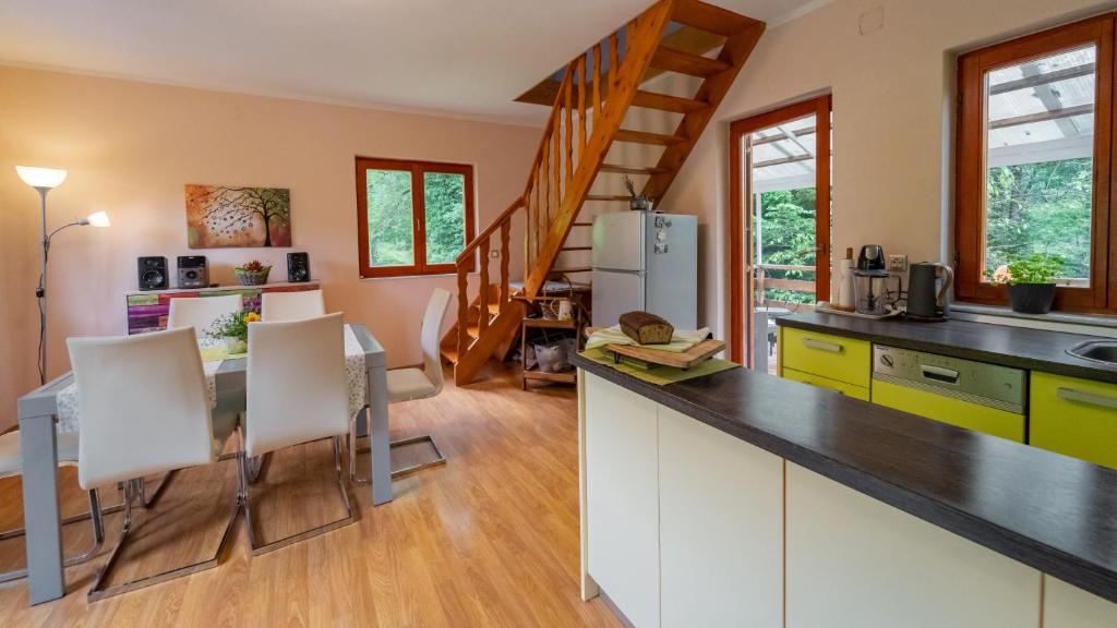 a kitchen and dining room with a table and chairs at Holiday house Kajfes in Brod na Kupi