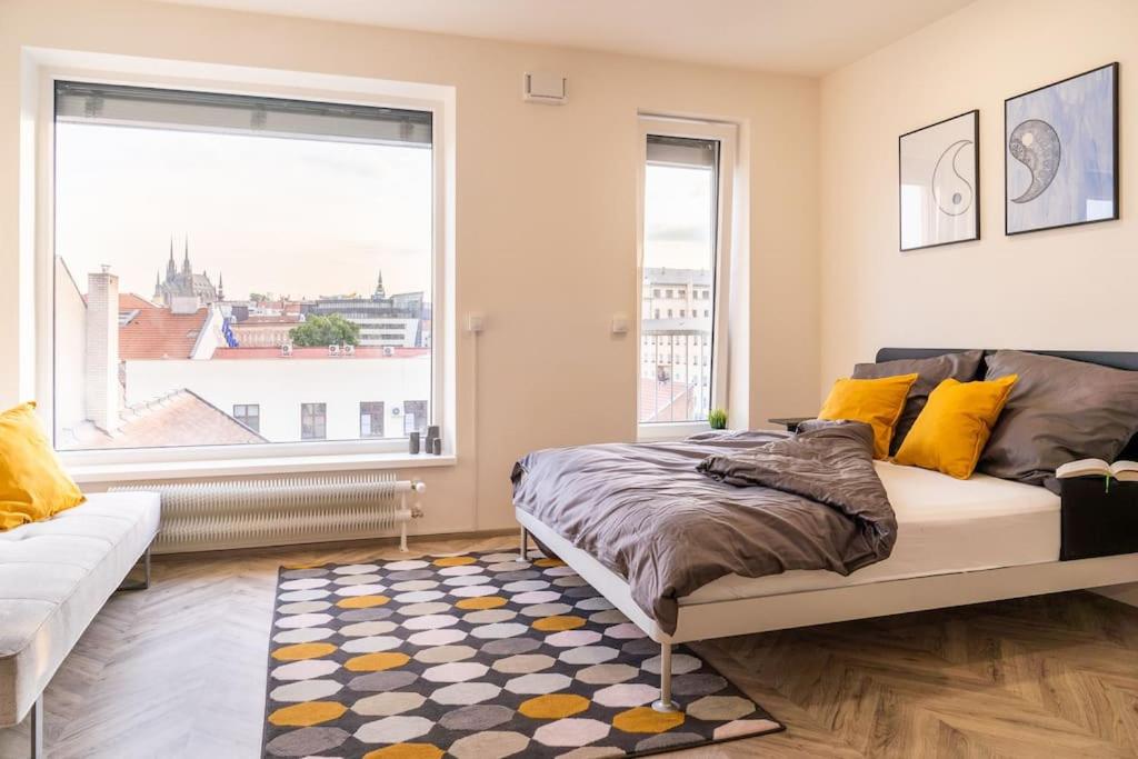 ein Schlafzimmer mit einem Bett und einem großen Fenster in der Unterkunft Brno Center View Apartement A - with self check-in in Brünn