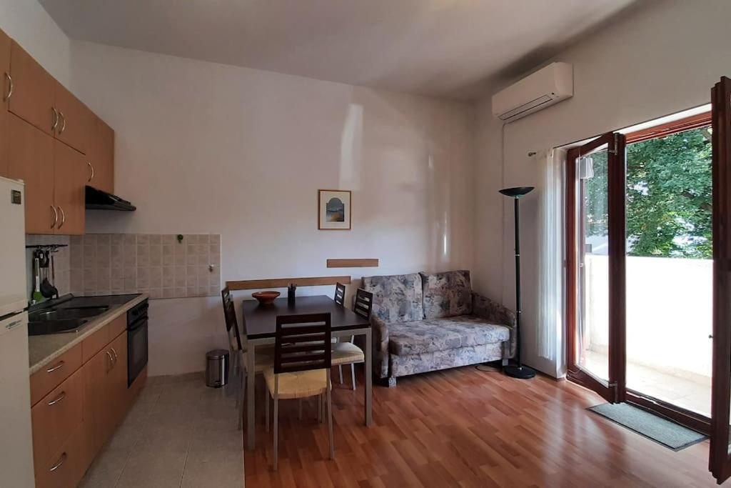 a kitchen and living room with a table and a couch at Quiet & Lovely Apartment-Ičići in Ičići