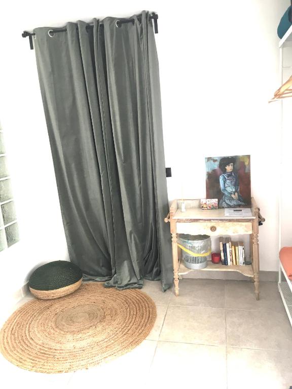 a room with a green curtain and a table at COSY ROOM PRIVATE BATH AND GARDEN in Anglet