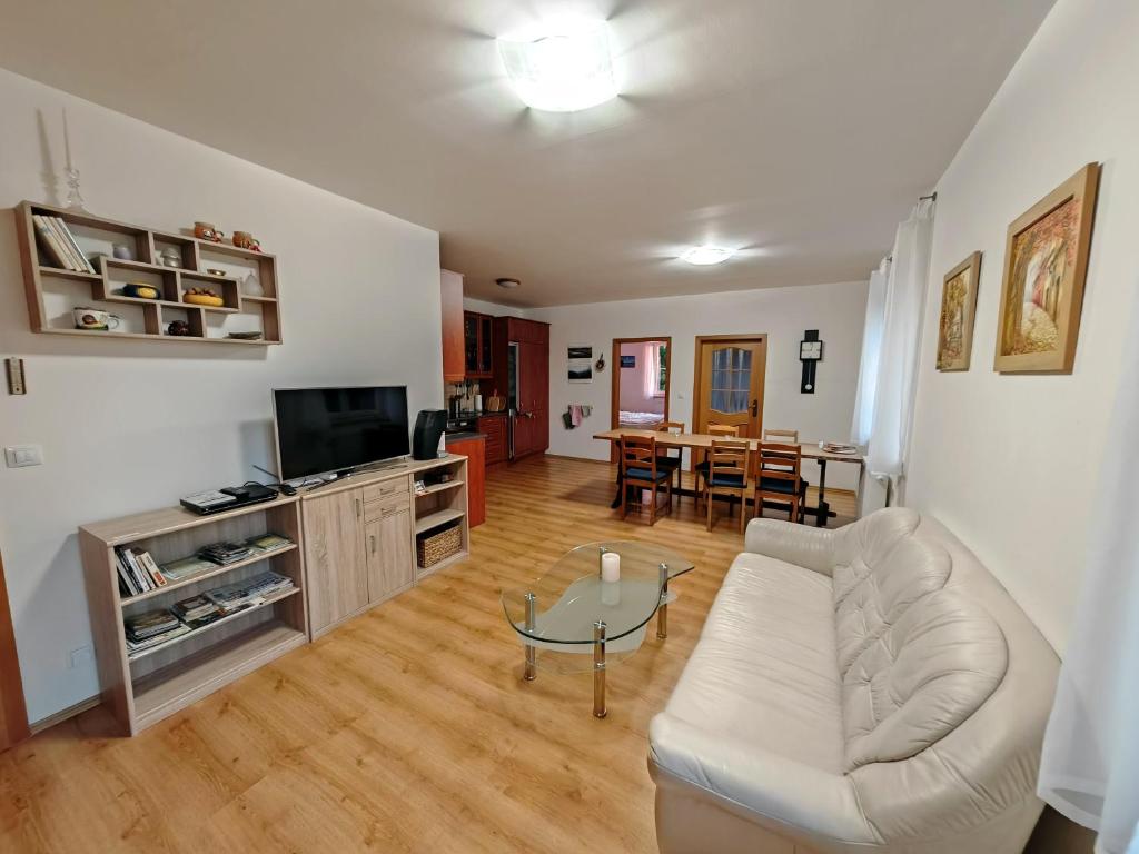 a living room with a white couch and a table at Špičák sruby - Horní dům in Špičák