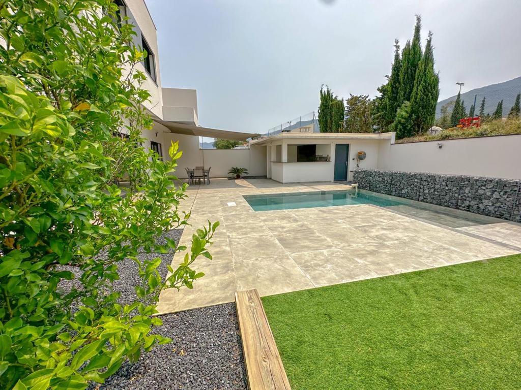 a backyard with a swimming pool and a house at L&#39;Attrape Rêves in Villelongue-dels-Monts