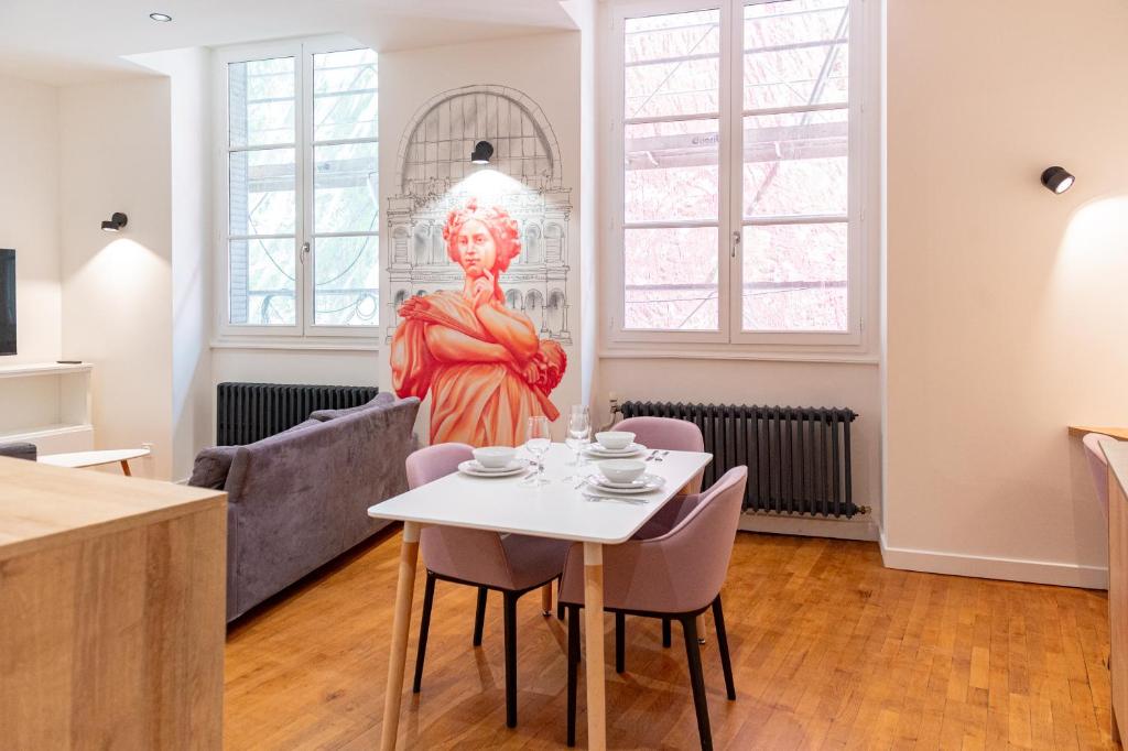 - une statue dans le salon avec une table et des chaises dans l'établissement Croix Paquet - Appartements à Lyon, à Lyon