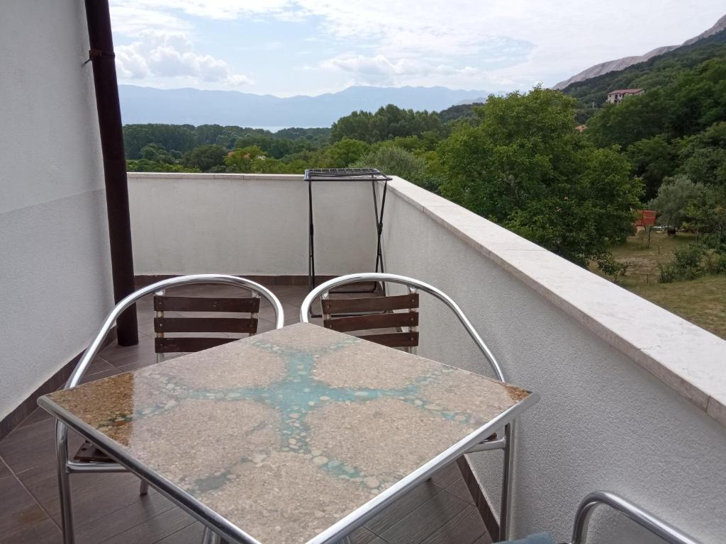 a table and chairs on a balcony with a view at KATY&MLADEN in Baška