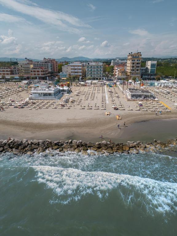 an aerial view of a beach with chairs and umbrellas at Hotel Augustus- Davanti a noi c'è solo il mare in Misano Adriatico