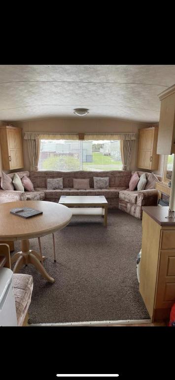 a living room with a couch and a table at S452 Golden Palm Resort in Chapel Saint Leonards