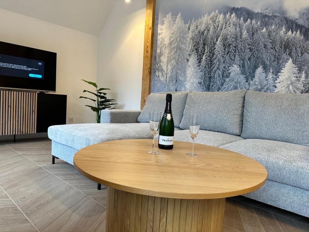 una sala de estar con una botella de vino en una mesa en Apartament Górska Osada 21 en Szklarska Poręba