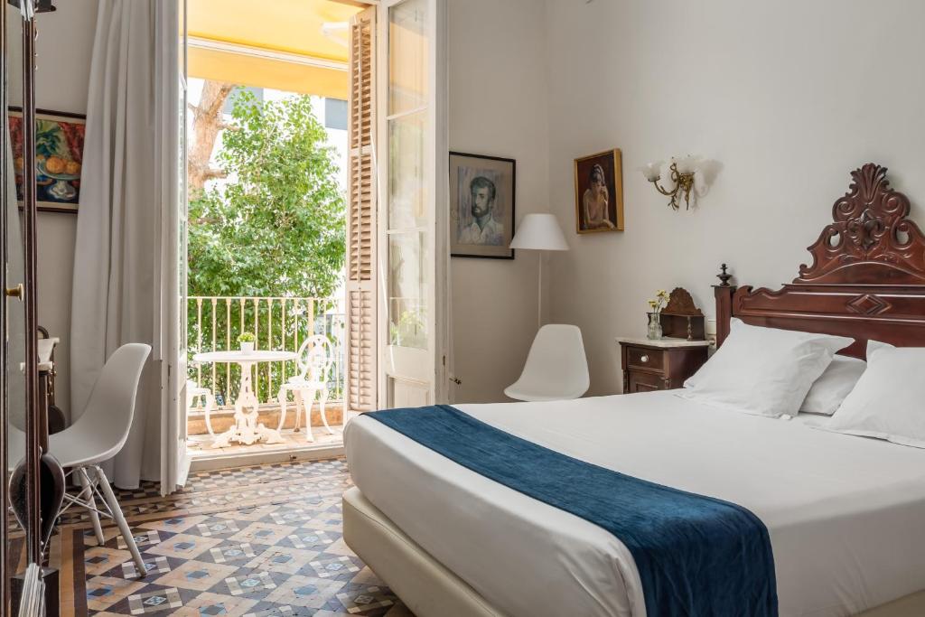 a bedroom with a bed and a large window at Hotel Medium Renaixença in Sitges