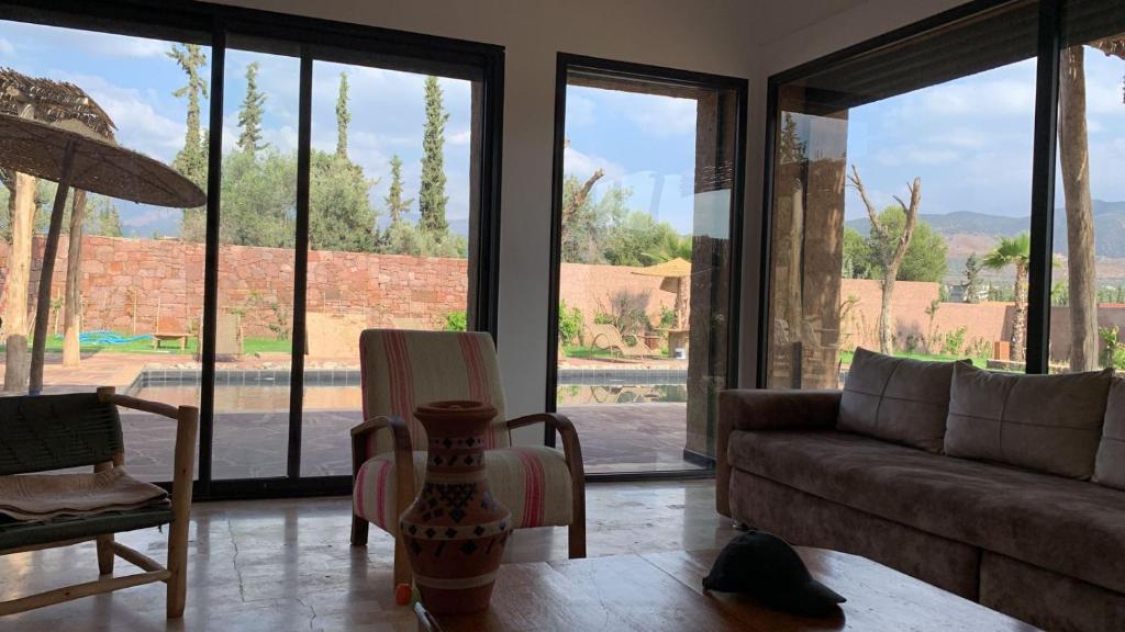 a living room with a couch and chairs and windows at Offrez-vous un moment de détente in Marrakesh