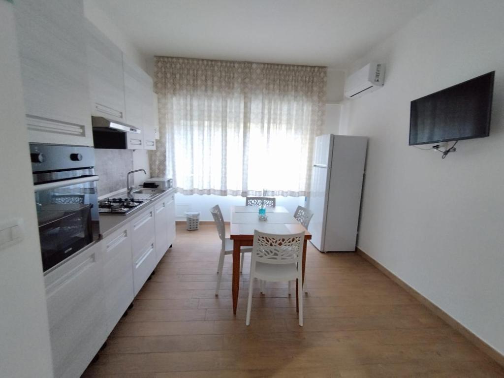 una cucina con tavolo, frigorifero, tavolo e sedie di Lela's room a Bari