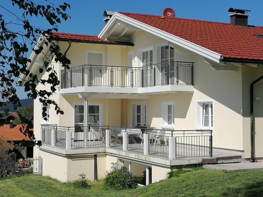 een wit gebouw met balkons en een rood dak bij Wunderschöne Ferienwohnung mit Seeblick in Zell am Moos
