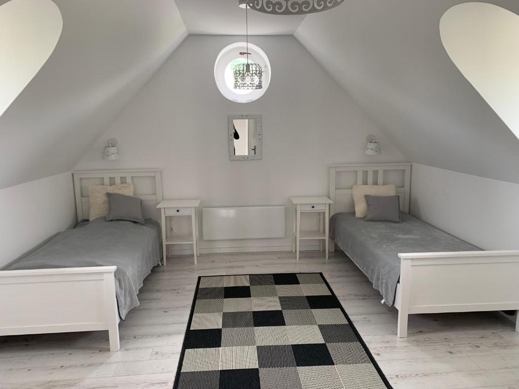 1 dormitorio en el ático con 2 camas y suelo a cuadros en Villa Léna, en Balatonederics