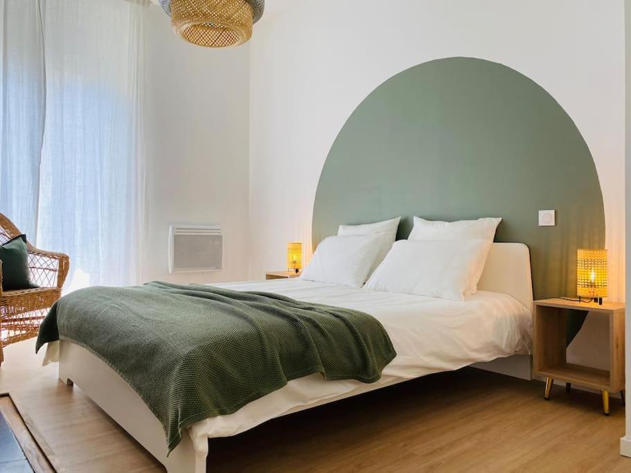 - une chambre avec un grand lit et une couverture verte dans l'établissement Le Condorcet. Charme et confort à Championnet, à Grenoble
