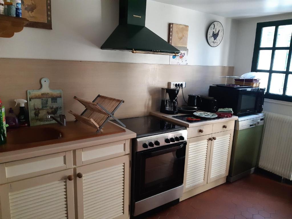 a kitchen with a stove and a sink at les orchidees sauvages in Touffreville-la-Corbeline