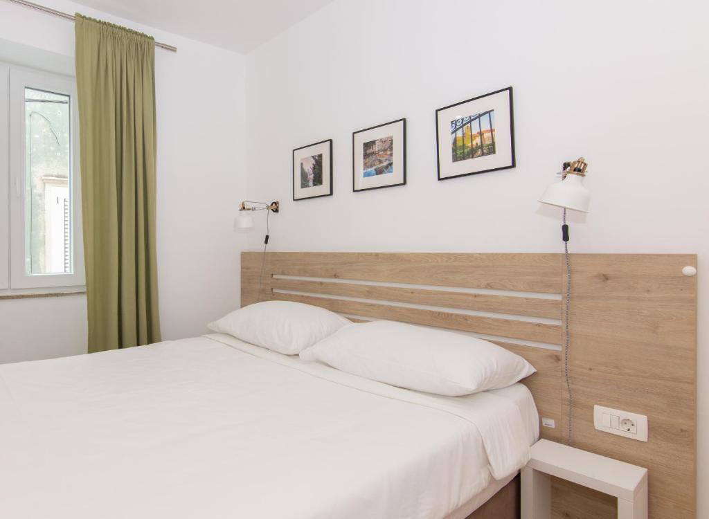 una camera con un grande letto con testiera in legno di Casa Mia - Apartments & Suites a Capodistria