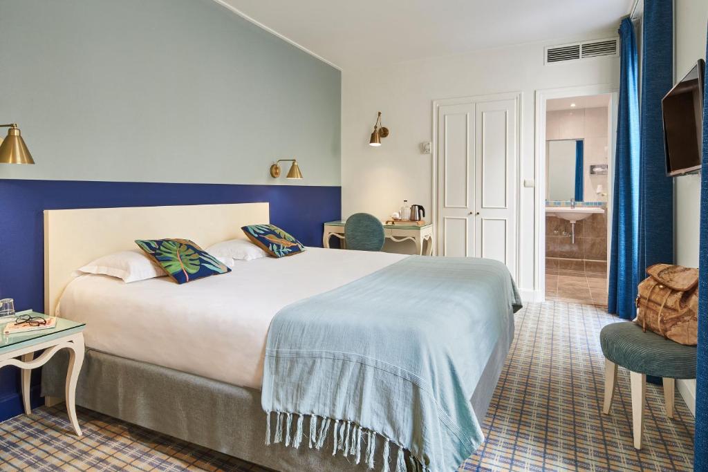 パリにあるHotel Etoile Saint Ferdinand by Happycultureの大きなベッドとバスルームが備わるホテルルームです。