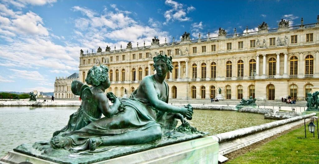 a statue in front of a large building at HOME VERSAILLES in Versailles