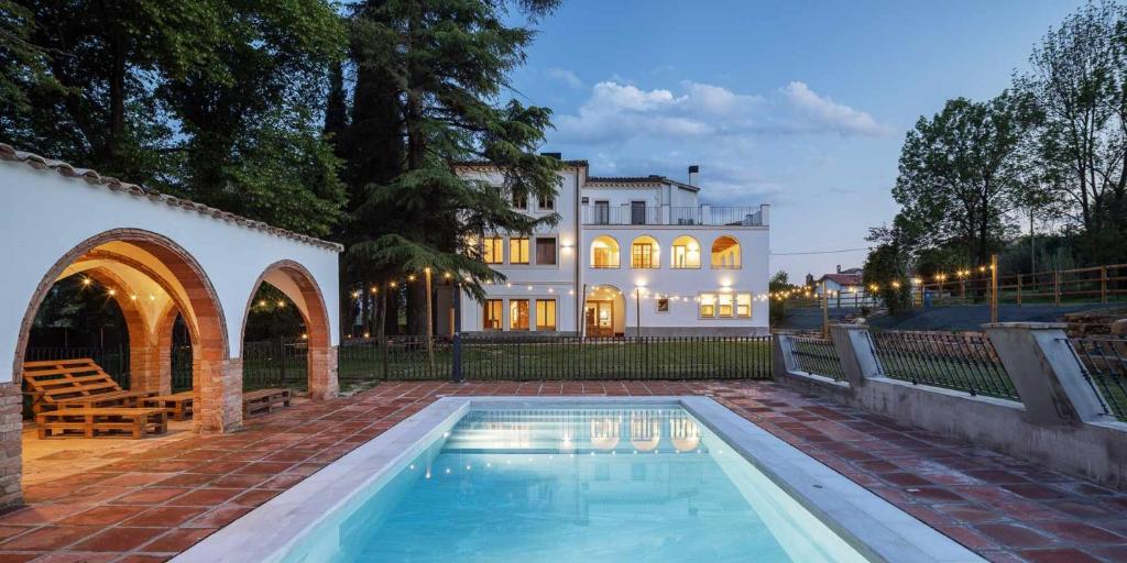 a swimming pool in front of a house at Can Passarells in San Vicente de Torelló