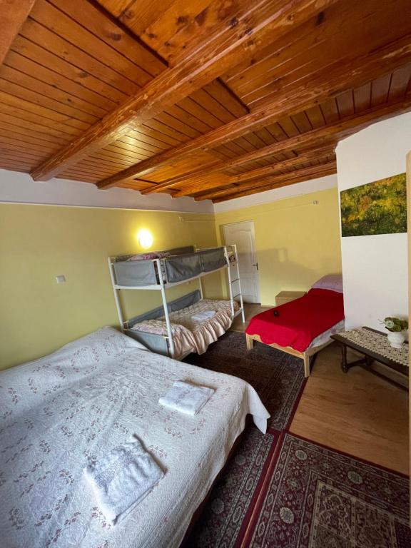 a bedroom with two bunk beds and a wooden ceiling at CONSTANTINESCU A. in Buşteni