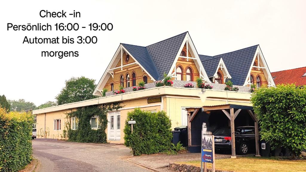 a house with a gambrel roof on top of it at Akzent Hotel Alte Direktionsvilla Kupfermühle in Flensburg