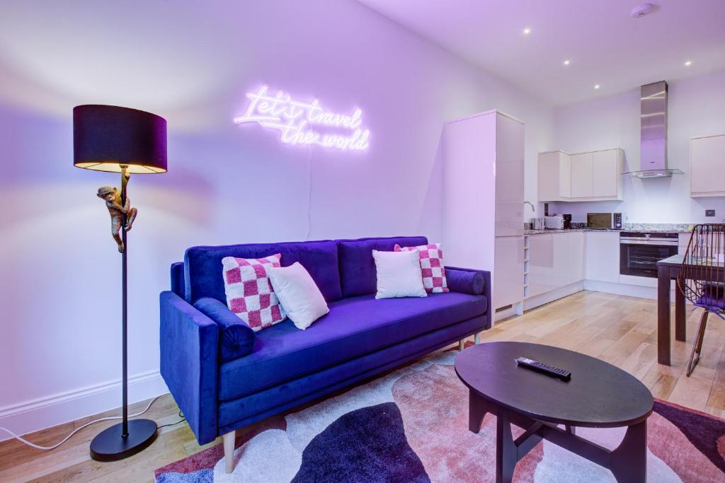 a living room with a purple couch and a table at Artsy Serviced Apartments - Ealing in London