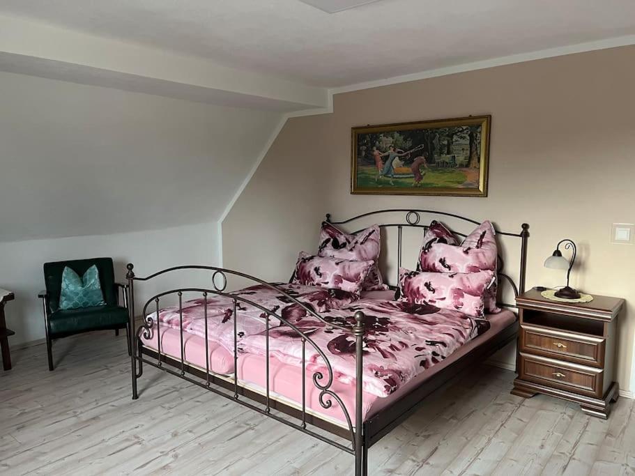 a bedroom with a bed with pink sheets and pillows at Haus Bernsteinsee mit Goitzsche-Schnuppersegeln in Friedersdorf