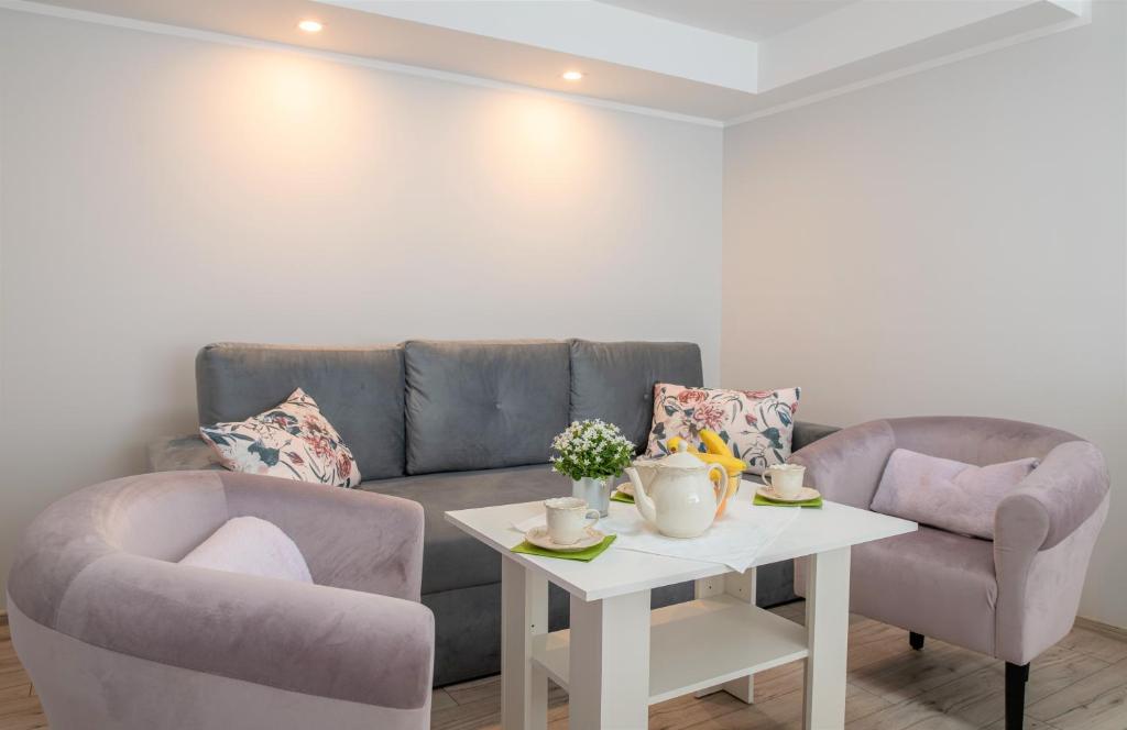 uma sala de estar com um sofá e duas cadeiras e uma mesa em Apartament Lawenda em Ciechocinek