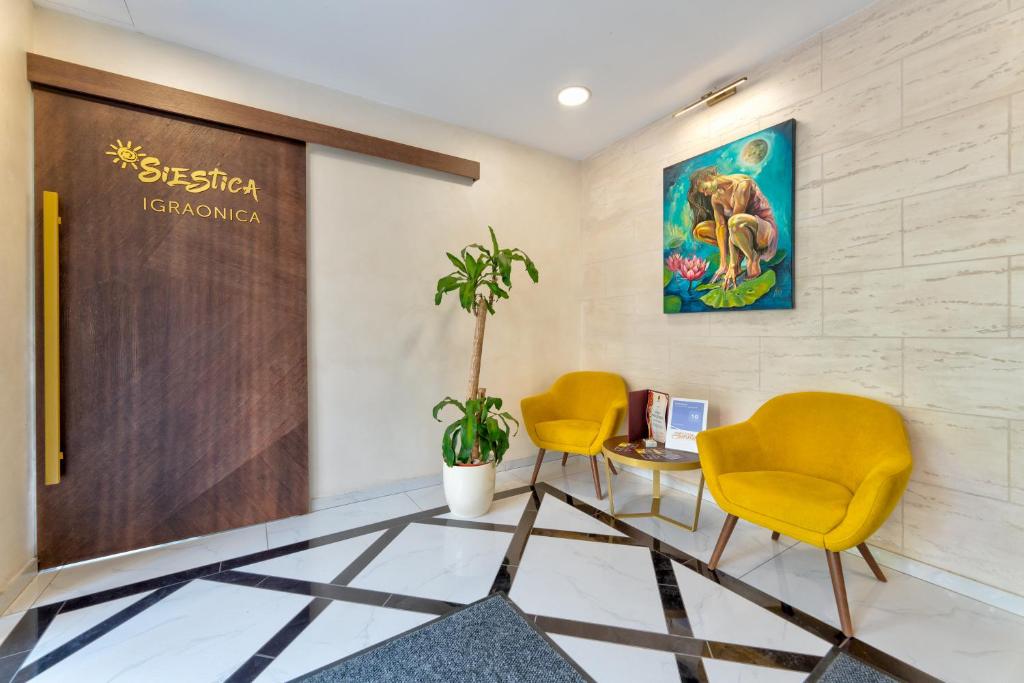 ein Büro mit 2 Stühlen und einem Schreibtisch mit einem Computer in der Unterkunft Hotel Siesta in Užice