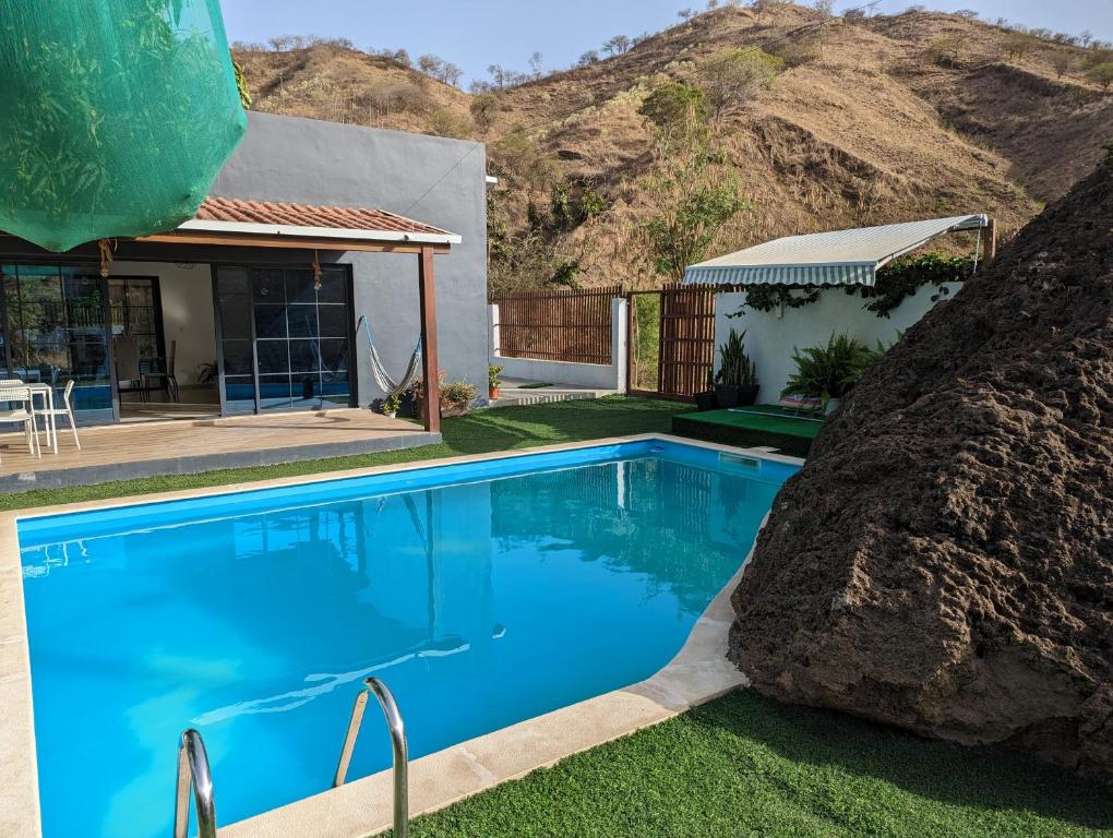 a swimming pool in front of a house with a mountain at Finca Pedra Molar in Órgãos