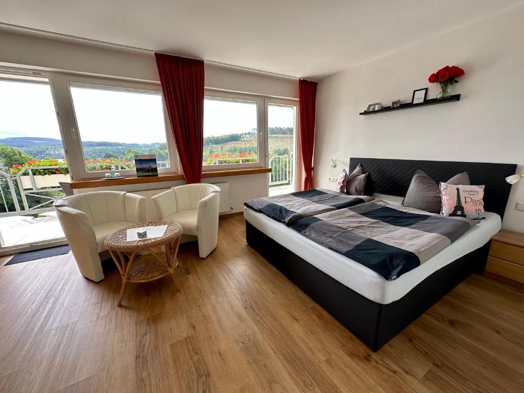 a bedroom with a bed and a table and chairs at Schnütgenhof Übernachtung am Biggesee in Attendorn