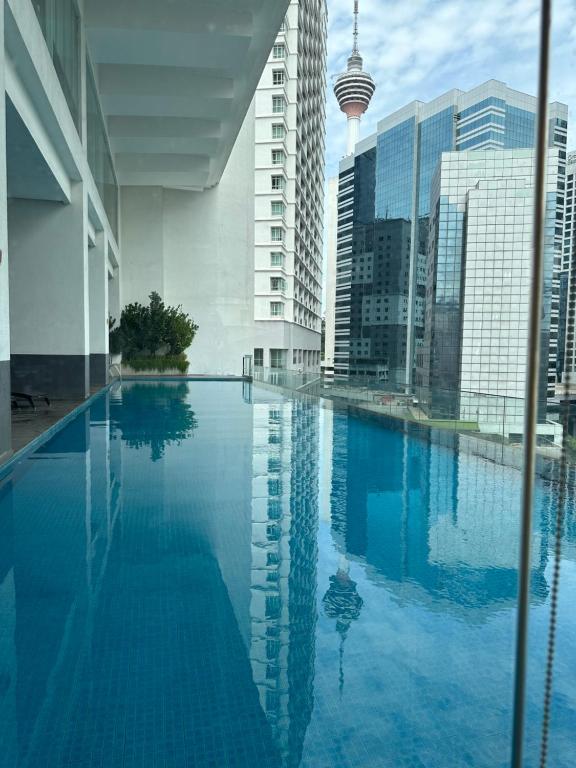a large swimming pool in a city with tall buildings at One Bukit Ceylon by Home Suites in Kuala Lumpur