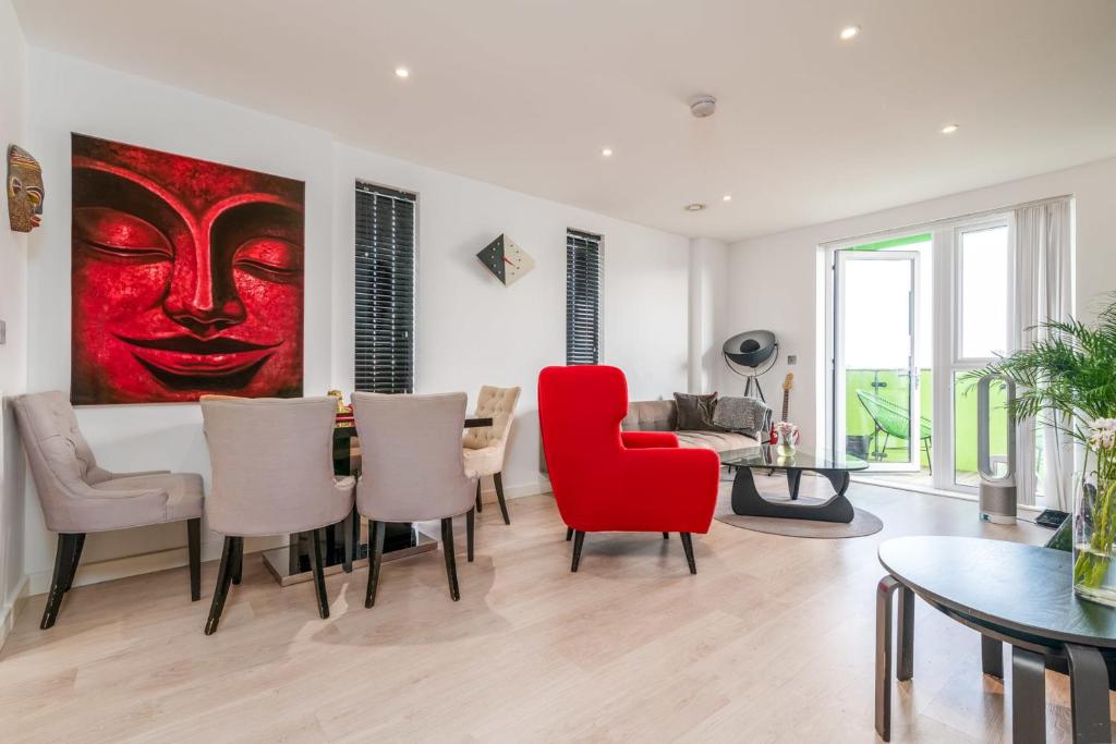 a living room with a red chair and a table at Gorgeous Wembley Flat in London