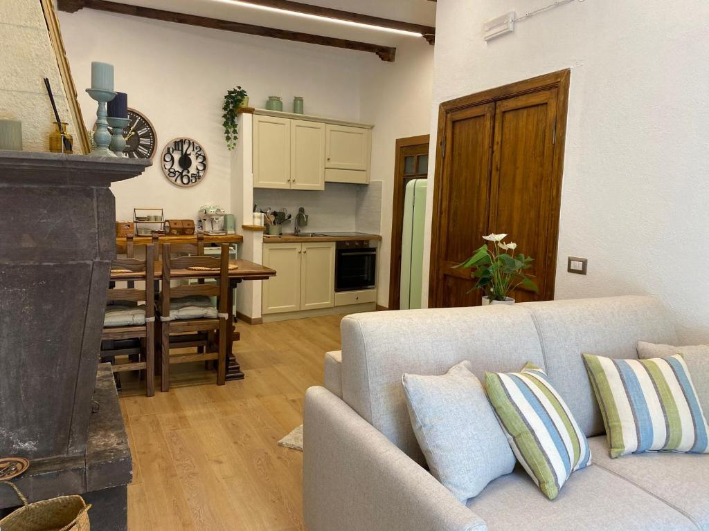 a living room with a couch and a table and a kitchen at All’ombra del museo in Tarquinia