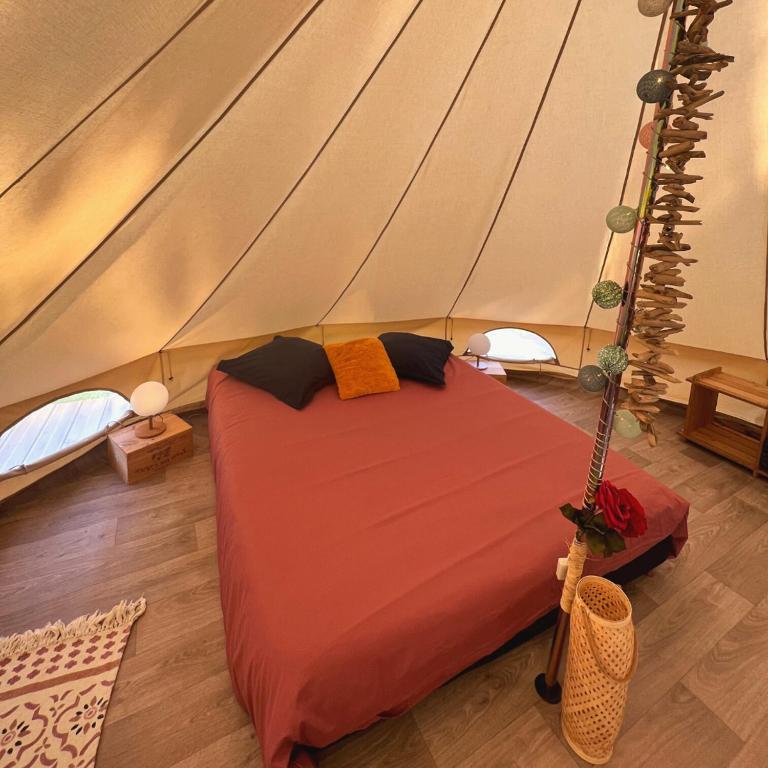 a bedroom with a bed in a tent at Le Tipi Glamour au bord de la rivière in Mios