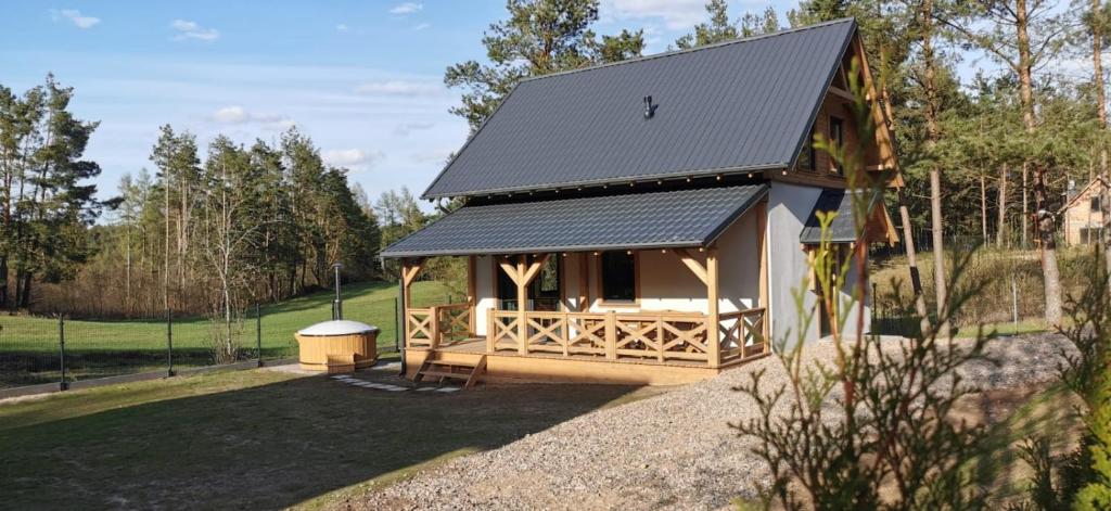 une petite cabine avec un toit noir dans un champ dans l'établissement Domki Gorąca Bania, à Gowidlino