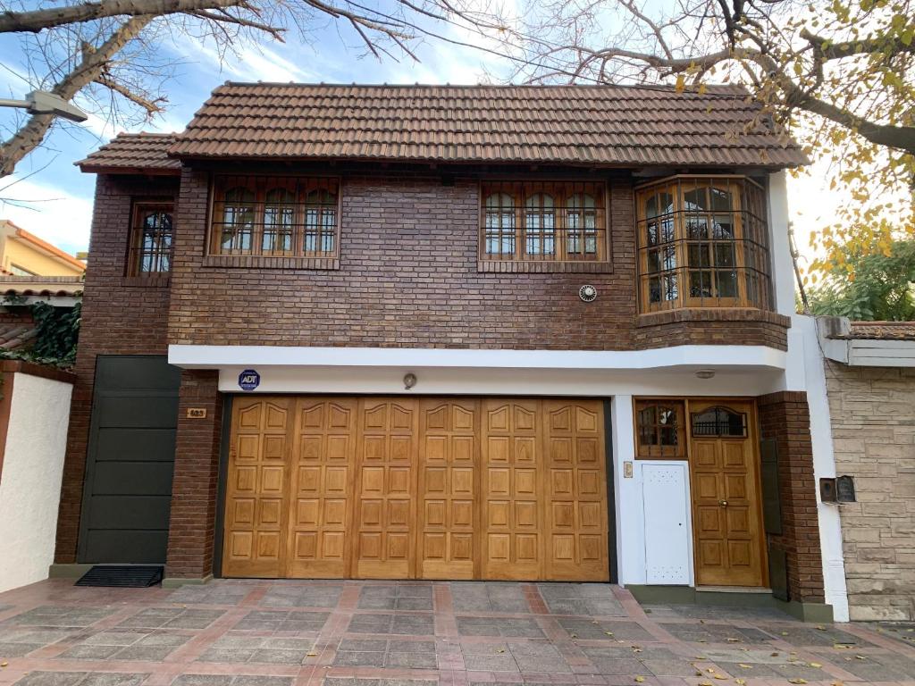 una casa con dos puertas de garaje delante de ella en Amplio departamento monoambiente a metros del parque general San Martín en Mendoza