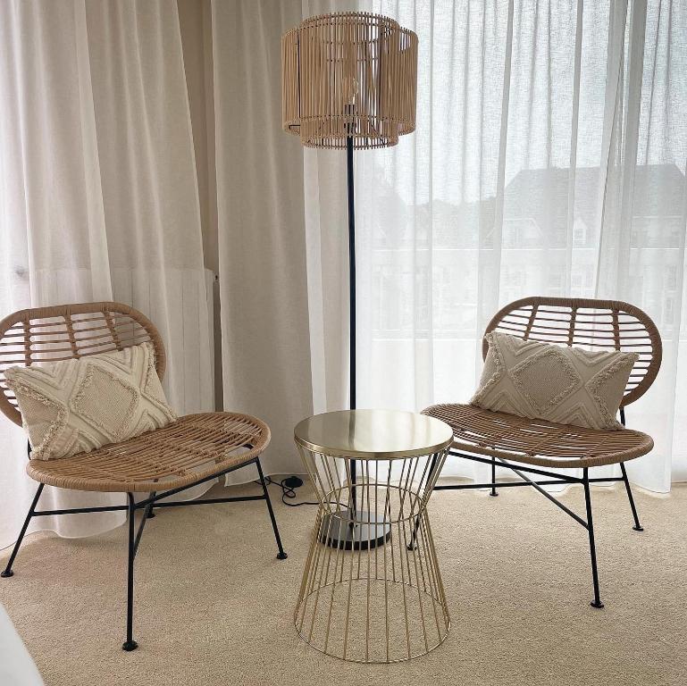 two chairs and a table and a lamp in a room at Hôtel Restaurant BO &amp; MIA in La Baule